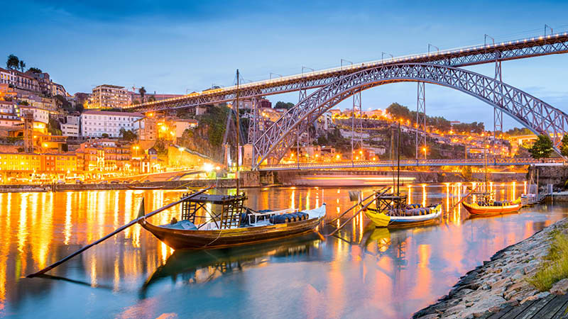 Porto stad vid floden i kvllsljus, i norra Portugal.